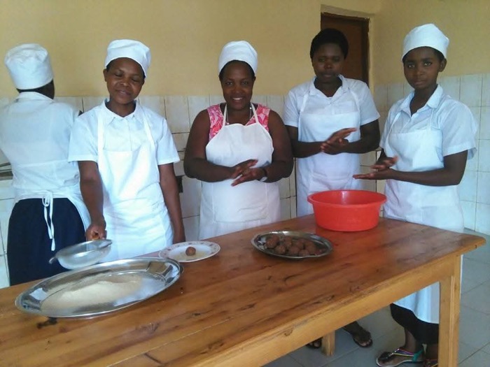 Young women in aprons learning vocational cooking skills together