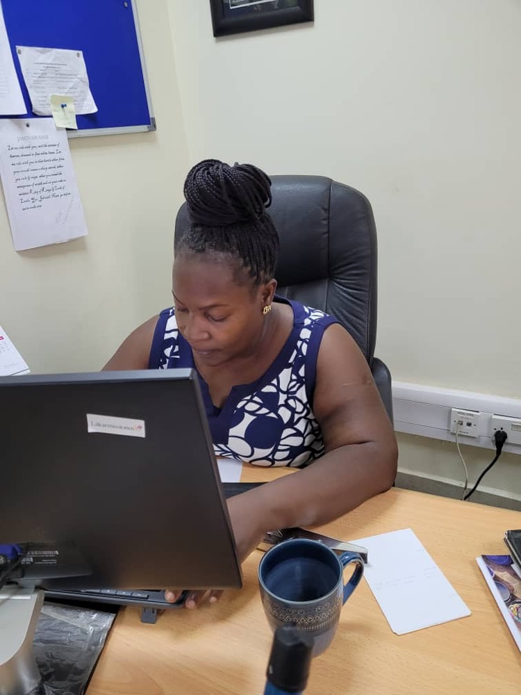 Rose Nyakato Kiiza working at her desk